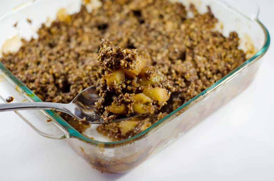 pan of paleo apple crisp with a spoon scooping out a serving