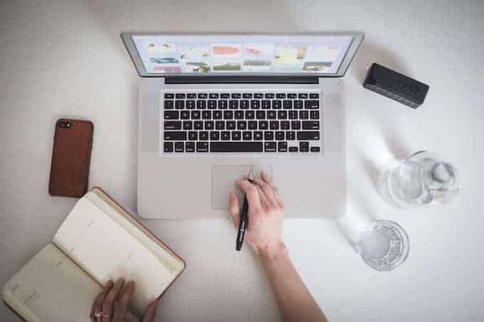 overhead view of person working with laptop, notebook, and pen