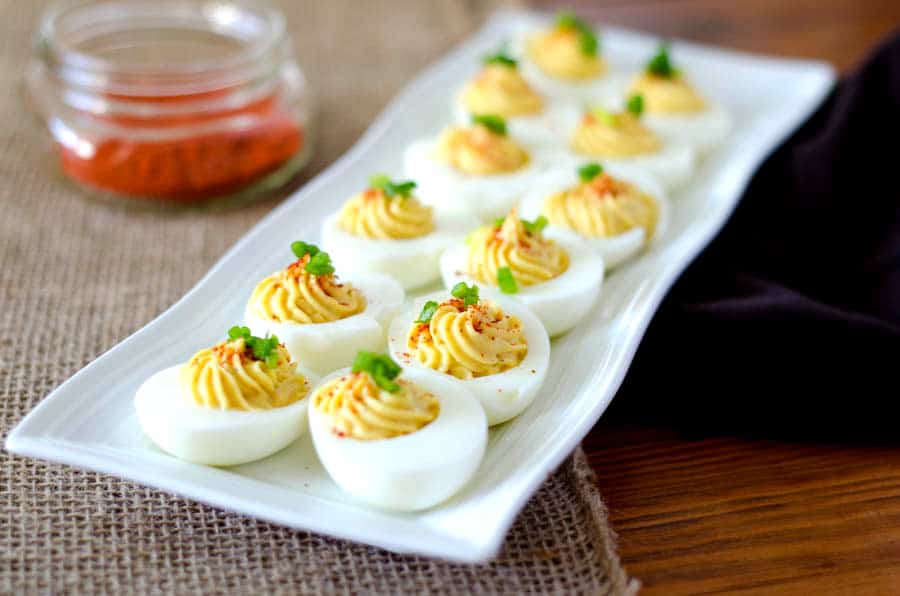 Side view of deviled eggs on a white platter