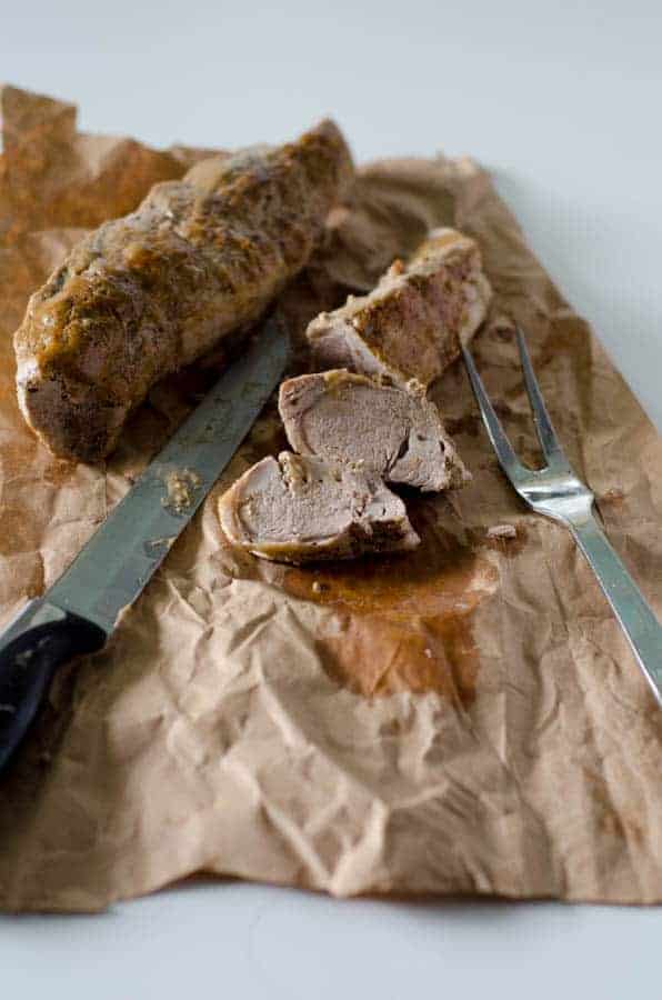 Whole30 pork tenderloin sliced on butcher paper with knife and fork