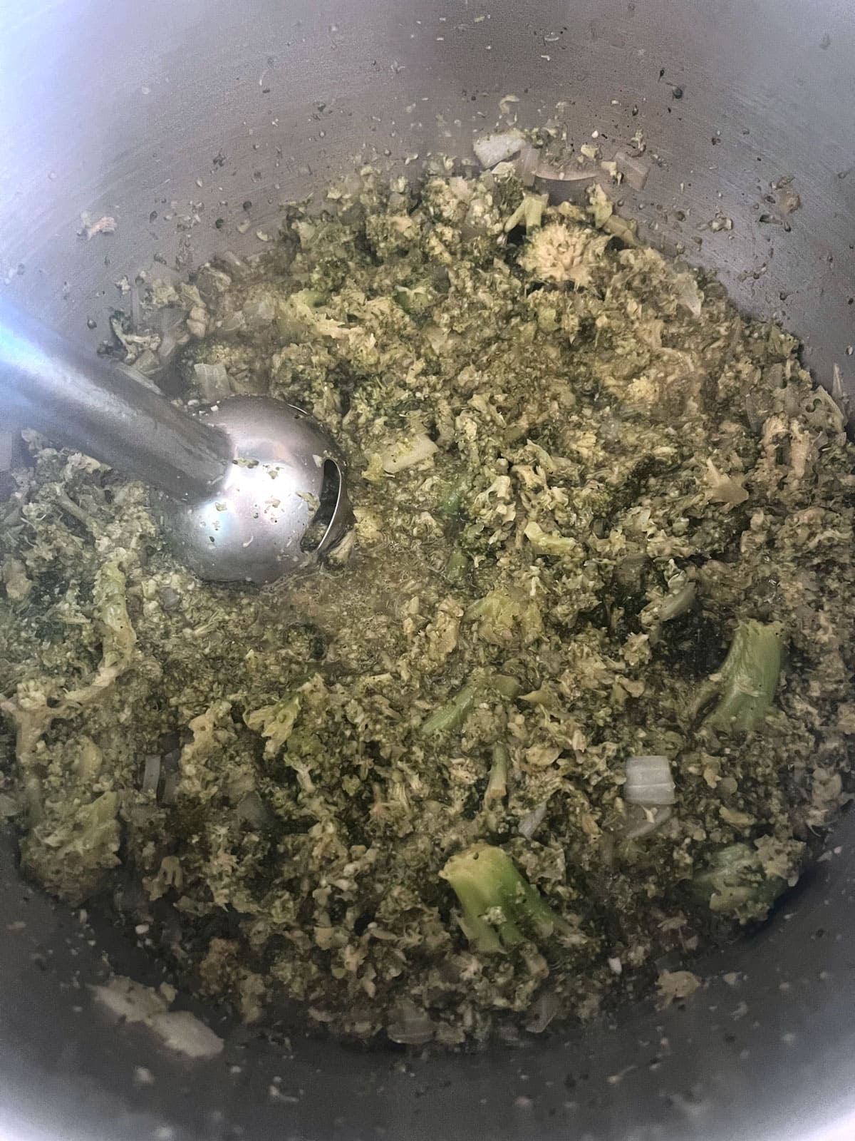 Broccoli soup ingredients being blended up with immersion blender