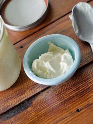 overhead view of an open jar of homemade mayonnaise with a bowl and spoon