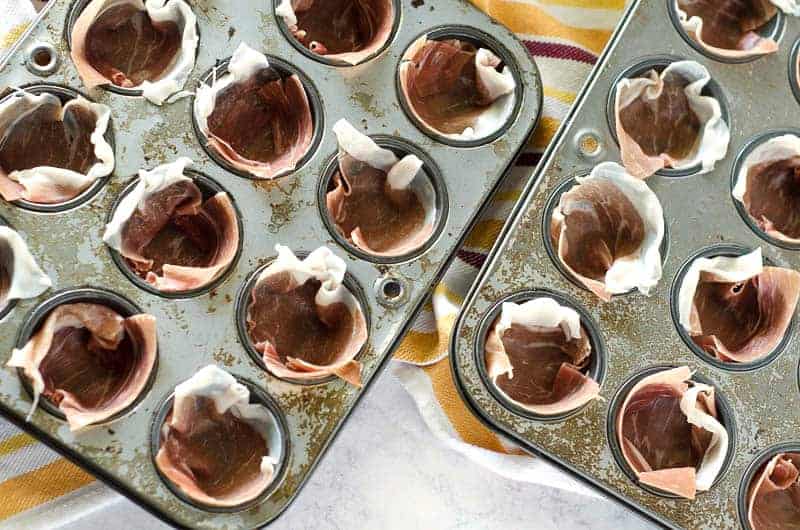 overhead view of mini muffin tins lined with proscuitto