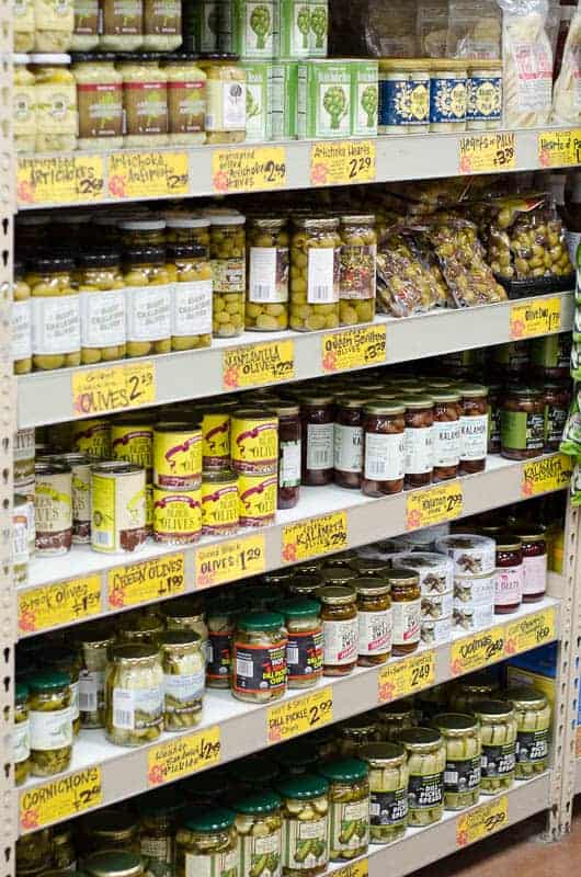 shelf of olives and pickles in grocery store