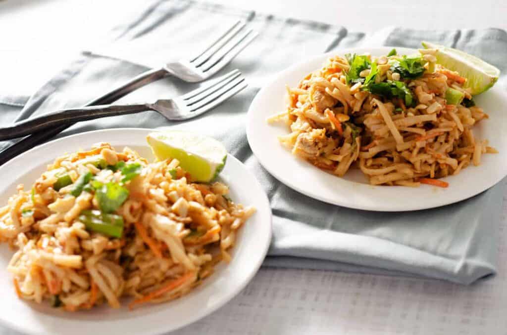 gluten free pad thai on two plates with two forks