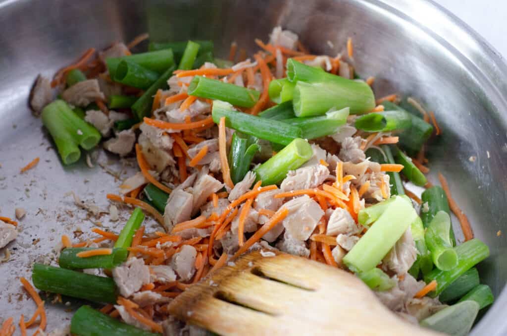 close up of stir fry pan with chicken, carrots, and green onions