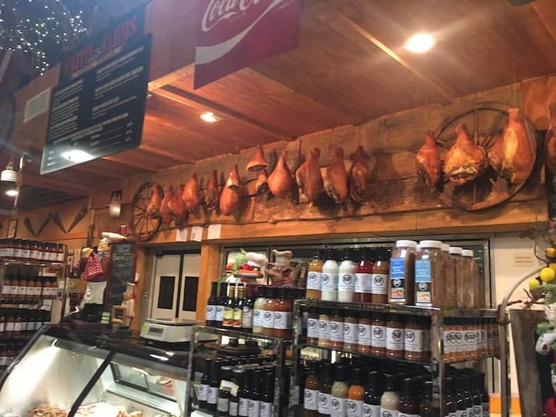 inside of family store with dried meats hanging behind butcher counter