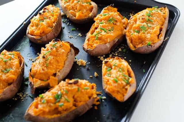 baking sheet with baked sweet potatoes cut in half