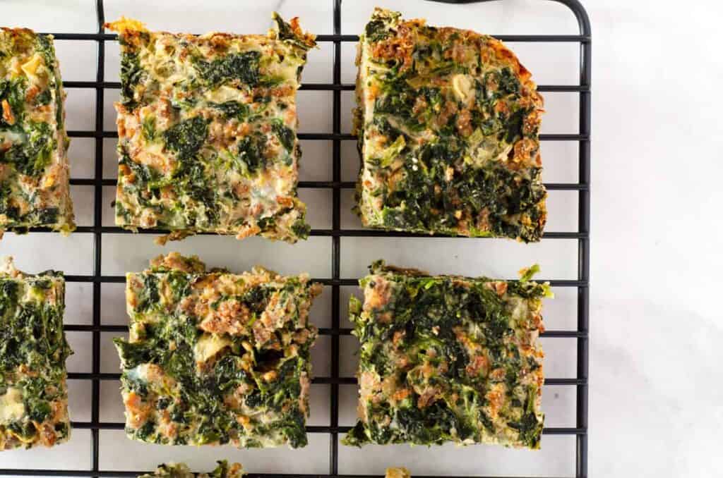 Overhead view of squares of spinach egg casserole cooling on a rack