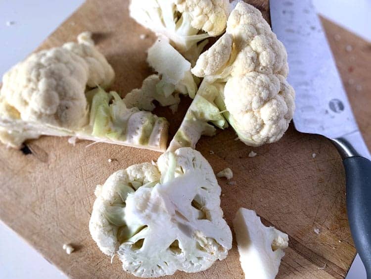 head of cauliflower cut up on cutting board