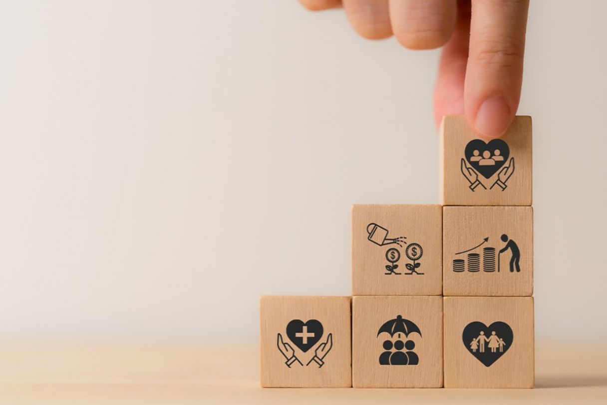 A hand placing a stack of wooden blocks printed with icon benefits