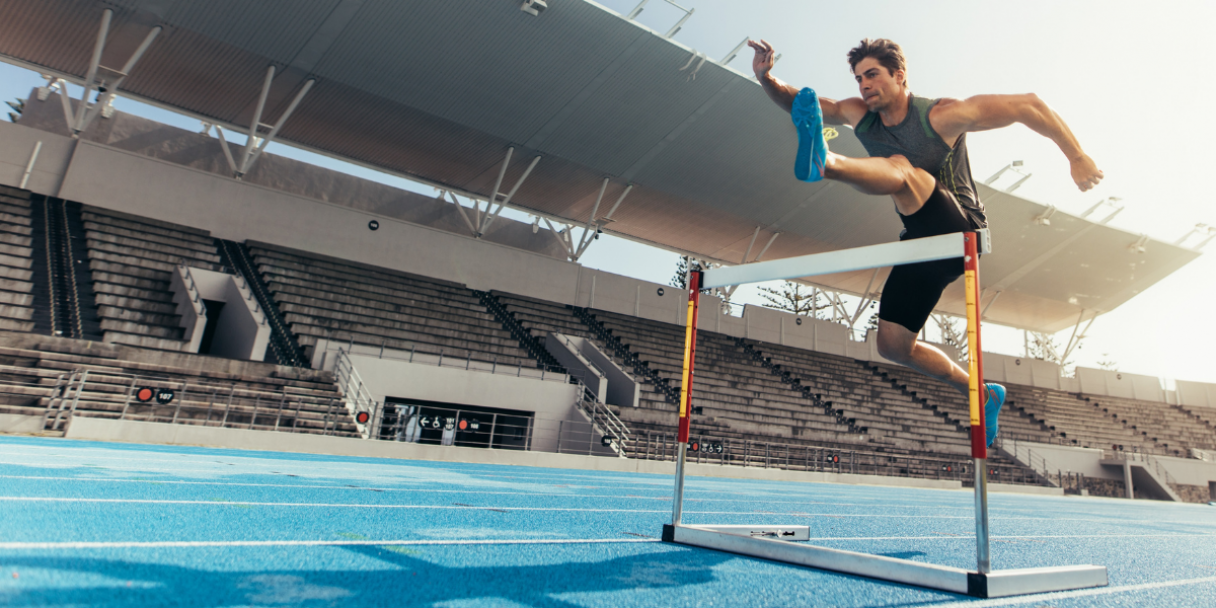 athlete jumping over a hurdle